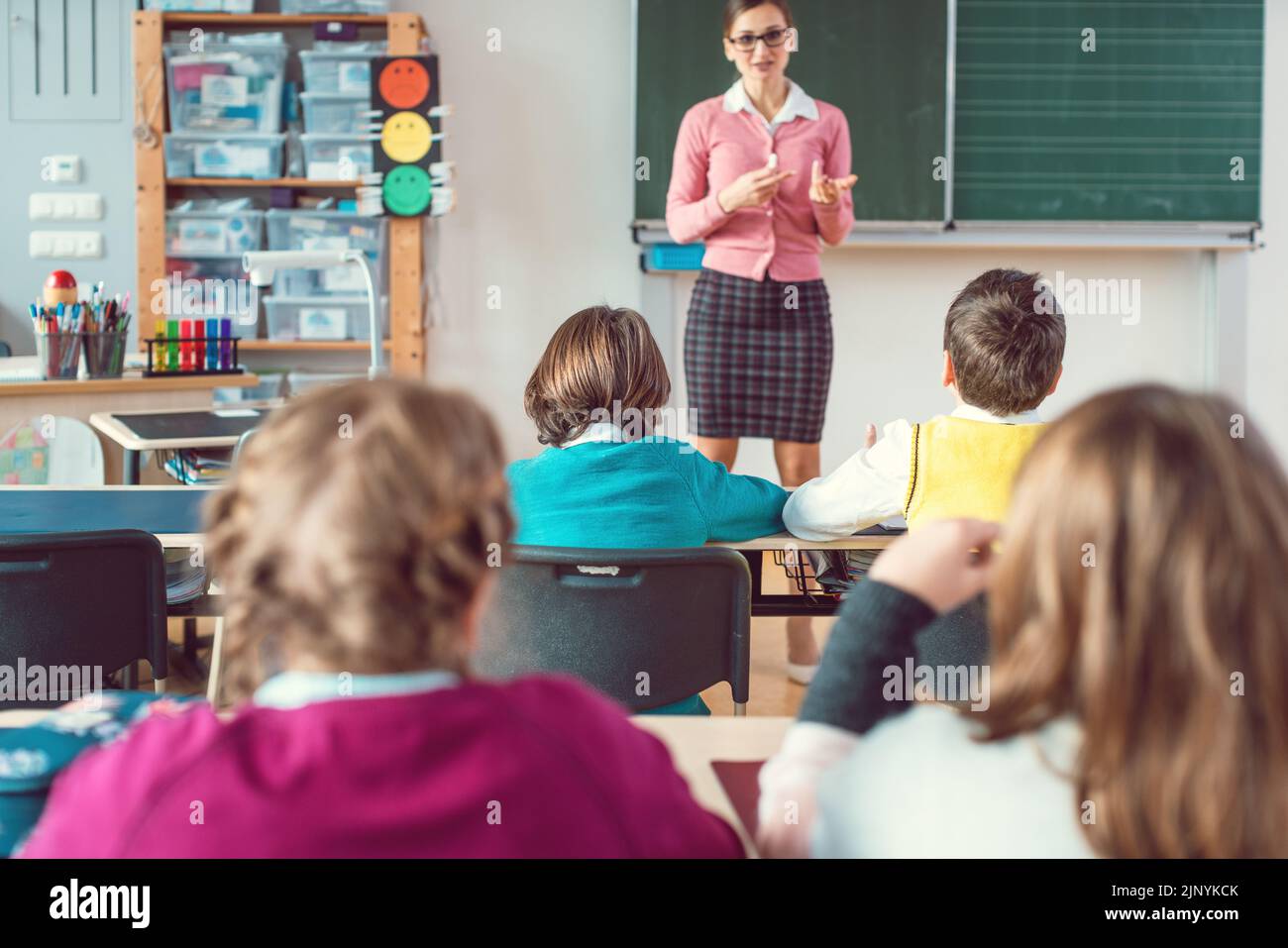 Teacher in class with fourth grade students in front of black board Stock Photo