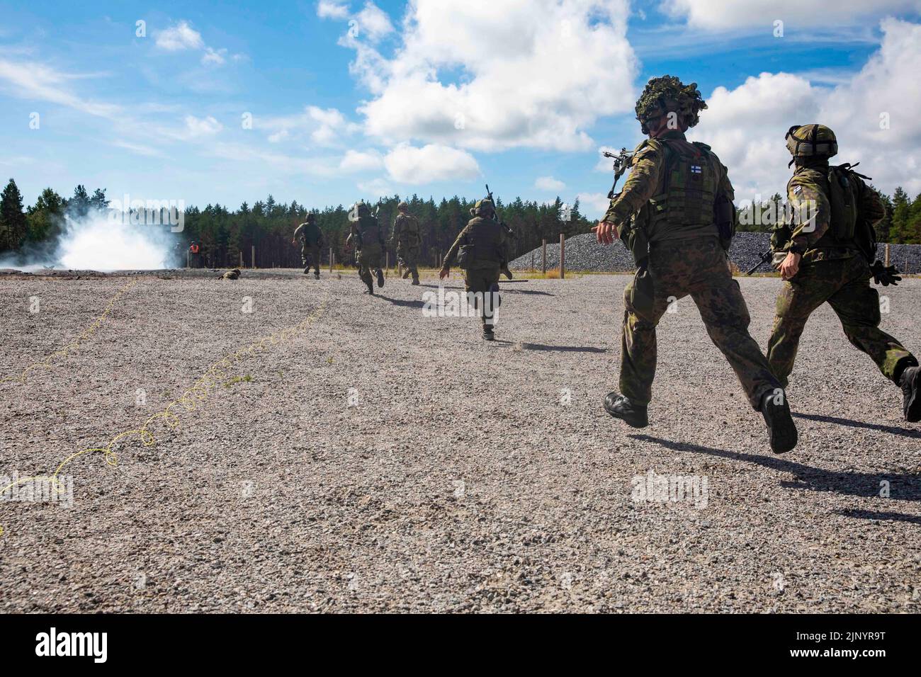 U.S. Marines assigned to Logistics Combat Element, 22nd Marine Expeditionary Unit (MEU), and Finnish soldiers from Nyland Brigade, run to provide security after detonating a bangalore torpedo explosive charge during demolition training in Syndalen, Finland, Aug. 11, 2022. The range was part of a bi-lateral exercise between the Finnish military and 22nd MEU. The Kearsarge Amphibious Ready Group and 22nd MEU, under the command and control of Task Force 61/2, is on a scheduled deployment in the U.S. Naval Forces Europe area of operations, employed by U.S. Sixth Fleet to defend U.S., allied and pa Stock Photo