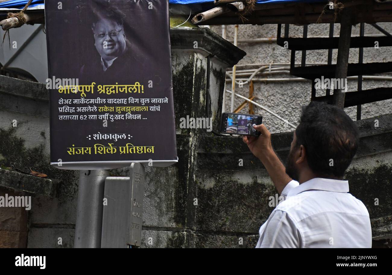 Mumbai, India. 14th Aug, 2022. A man takes a photo of a poster paying ...