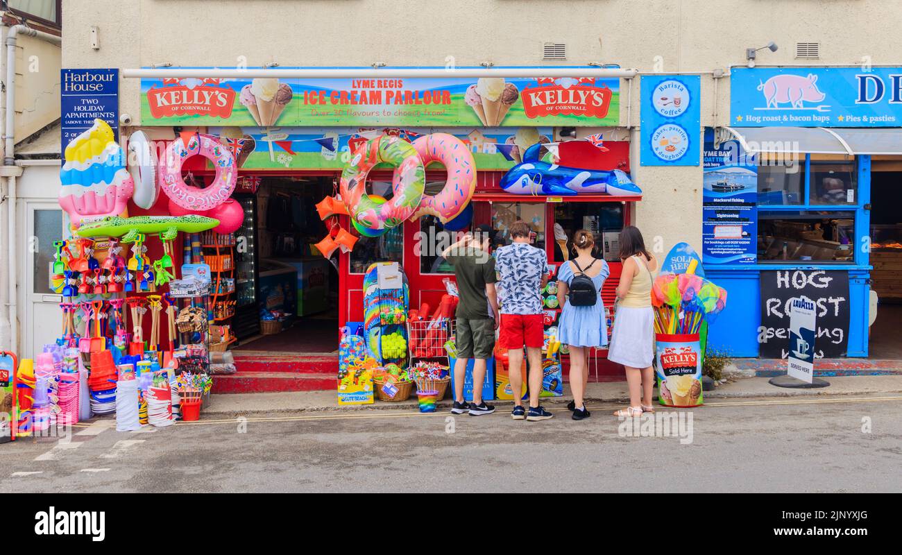 Ice cream parlour and roadside display of inflatables and beach toys in a shop by the Cobb, Lyme Regis on the Jurassic Coast in Dorset, south England Stock Photo