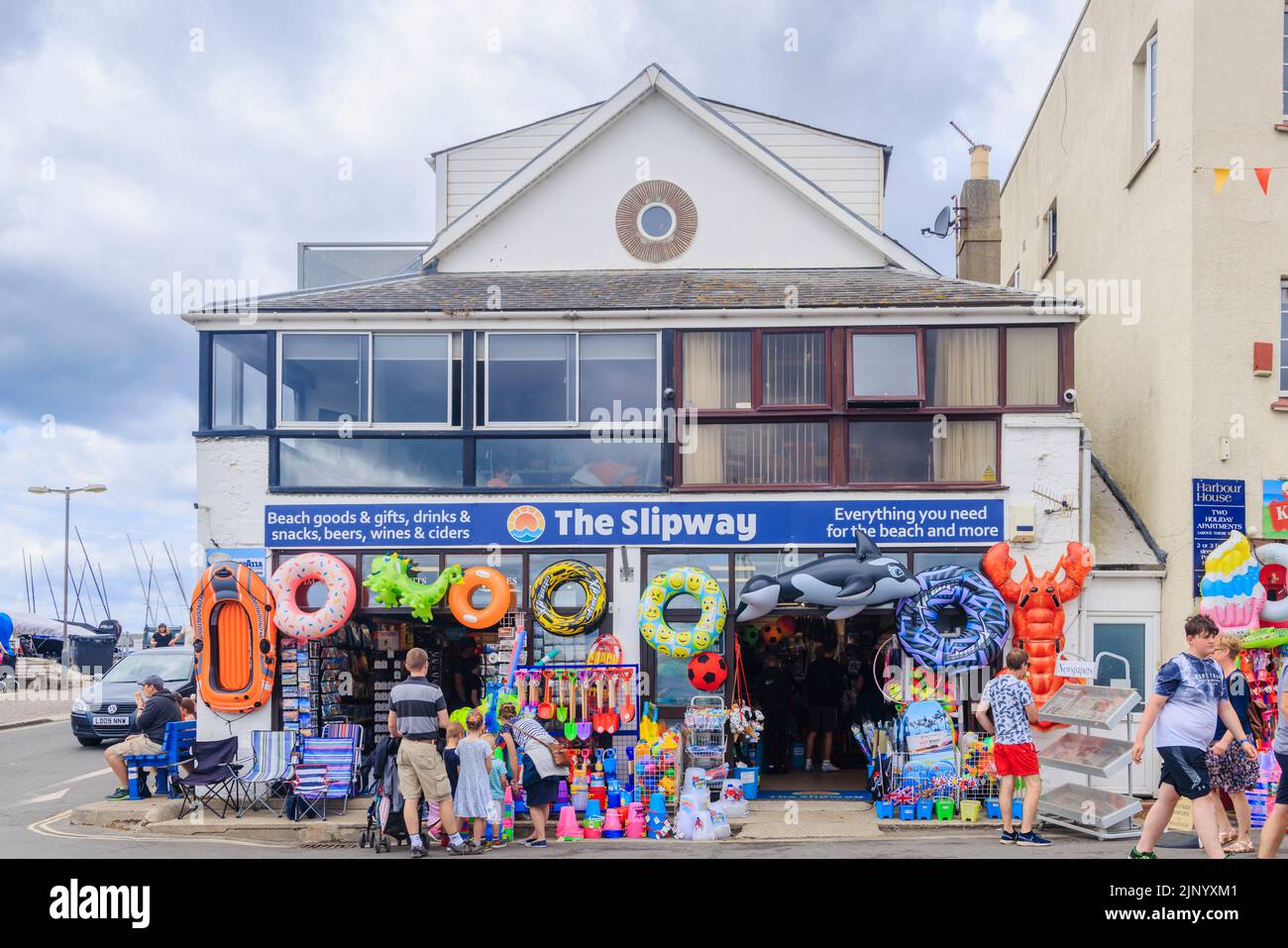 Roadside display of colourful inflatables and beach toys in a shop by the Cobb in Lyme Regis on the Jurassic Coast in Dorset, south England Stock Photo