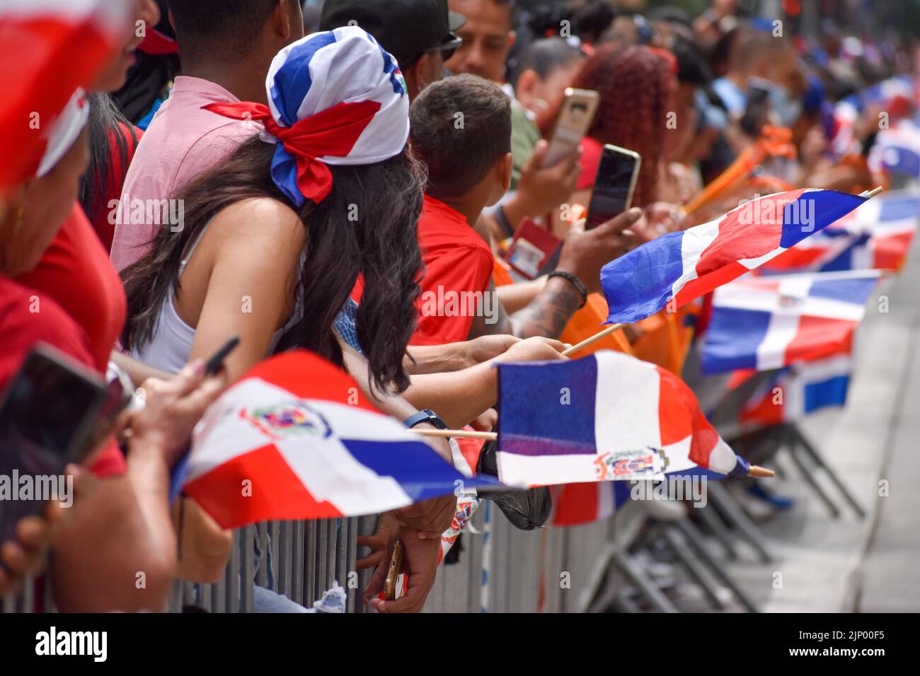 New Yorkers of all ages are seen wearing Dominican flag during the Dominican Day Parade on Sixth Avenue in New York City. Stock Photo