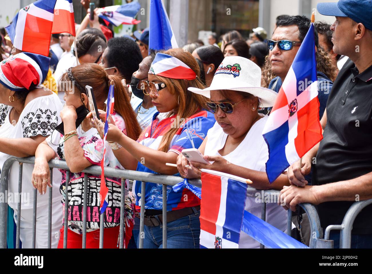 New Yorkers of all ages are seen wearing Dominican flag during the Dominican Day Parade on Sixth Avenue in New York City. Stock Photo