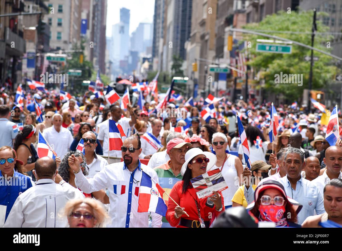 A group of people is marching along Sixth Avenue during the annual Dominican Day parade on August 14, 2022 in New York City. Stock Photo