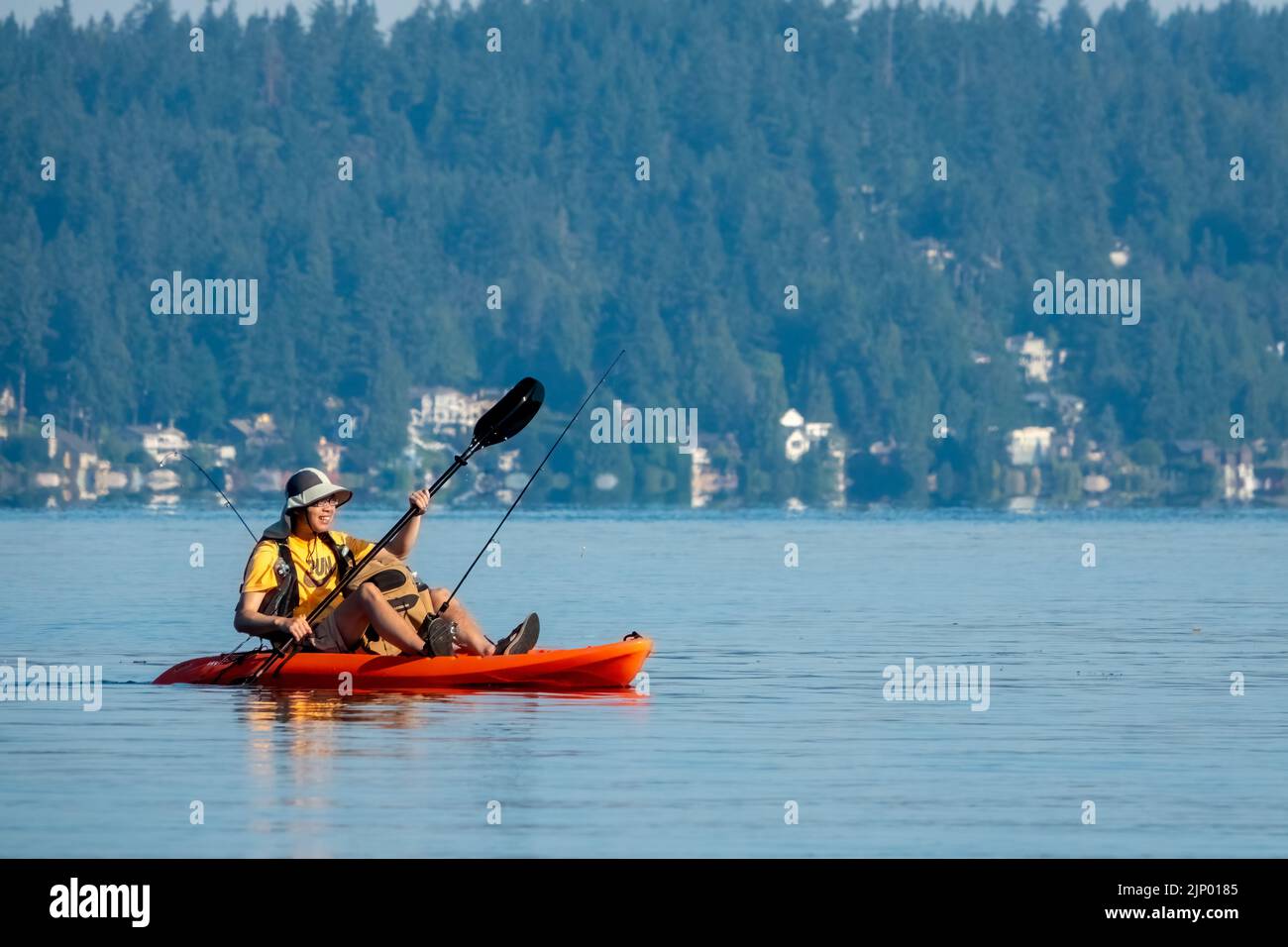 Issaquah, Washington, USA.  Man kayaking in a sit-on-top kayak with fishing rod in Lake Sammamish. Stock Photo