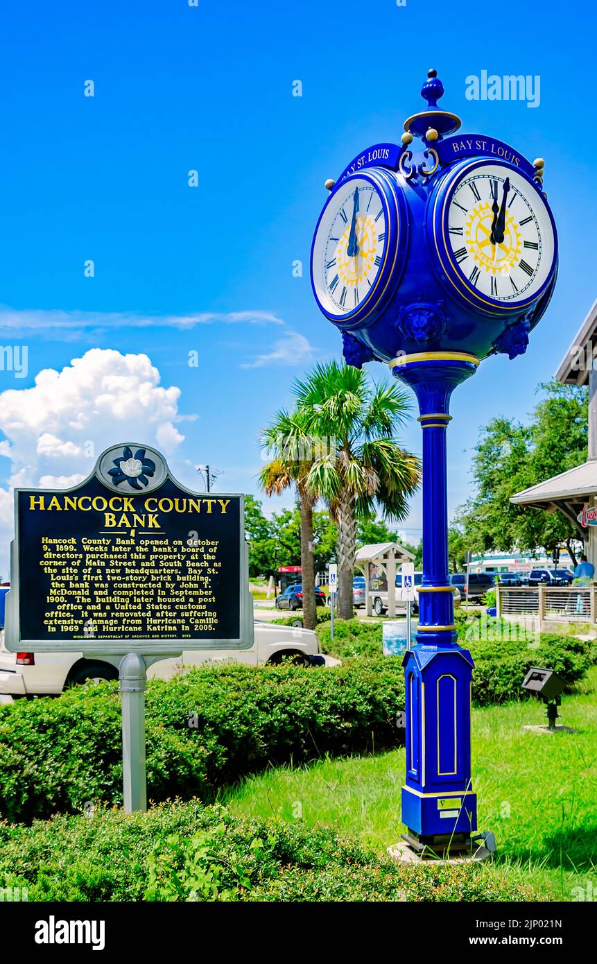 The Bay Saint Louis clock stands alongside a historic marker for Hancock County Bank, Aug. 13, 2022, in Bay Saint Louis, Mississippi. Stock Photo