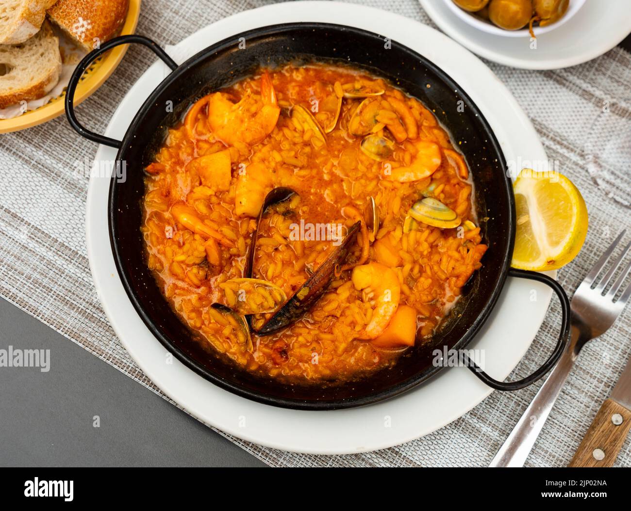 Paella marinera with shrimps and mussels served on iron frypan Stock