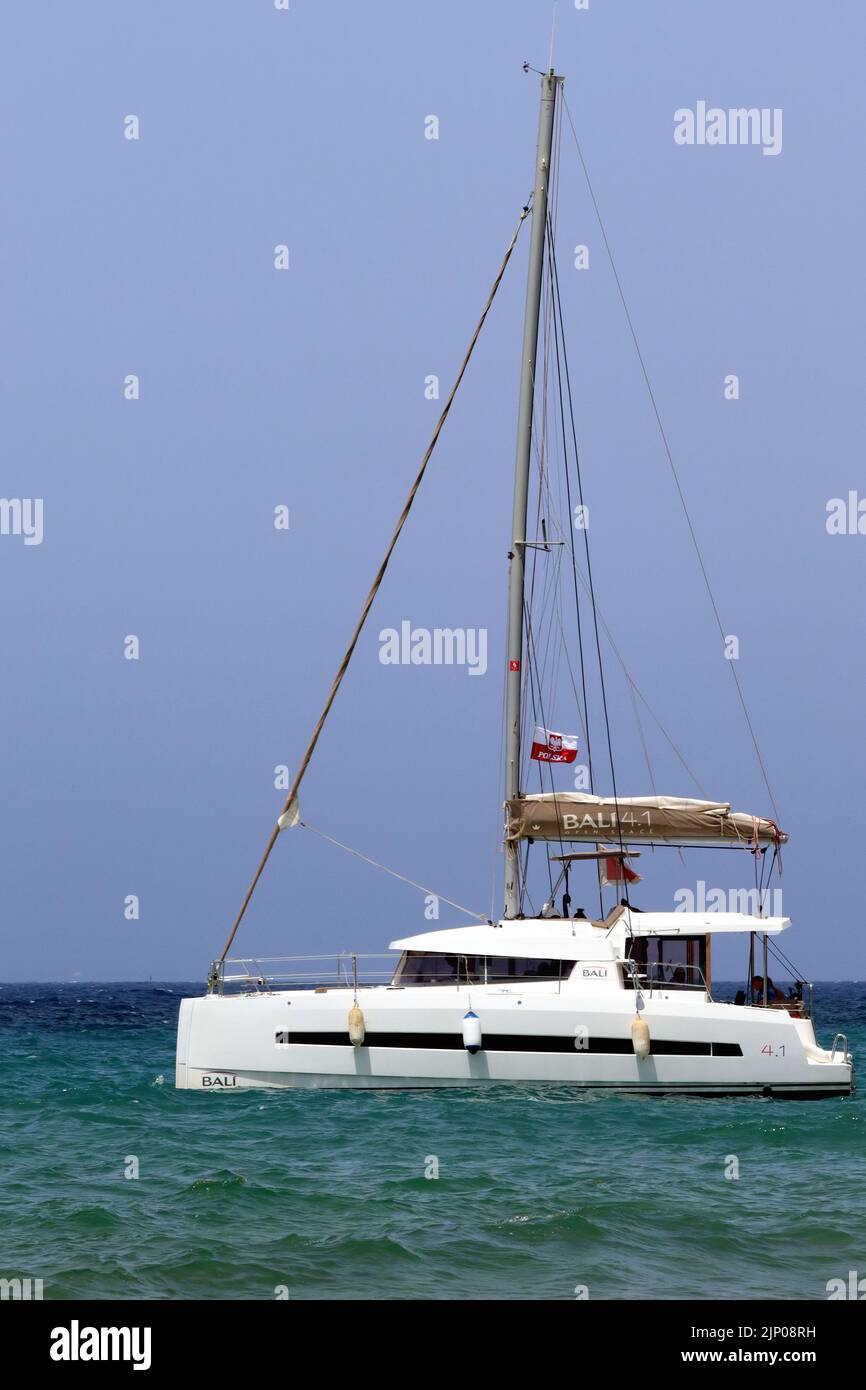 Guests relaxing aboard a Bali 4.1 luxury catamaran, anchored at Ramla Bay, Gozo, Malta. Stock Photo