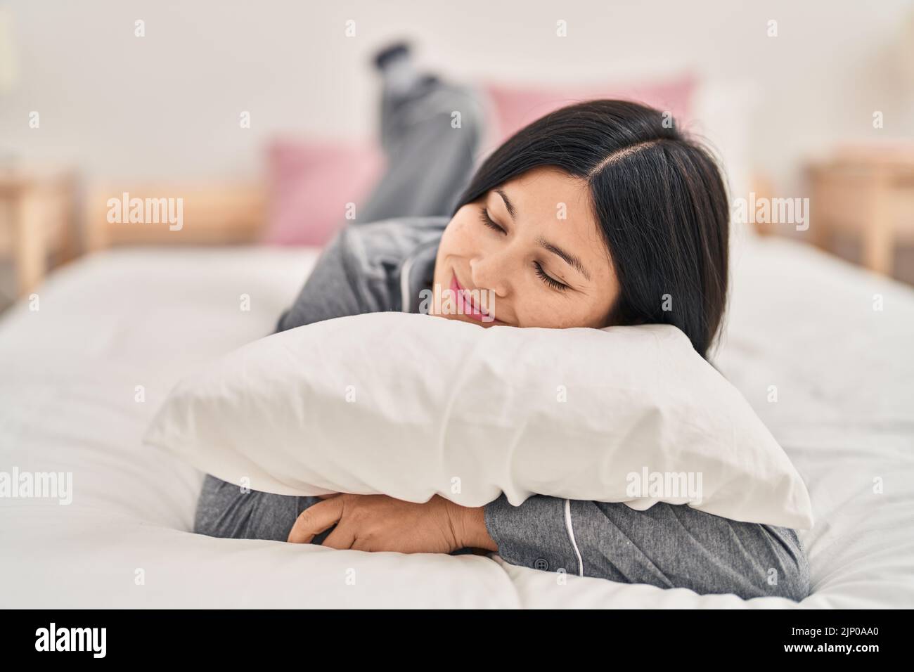 Young chinese woman smiling confident lying on bed at bedroom Stock ...