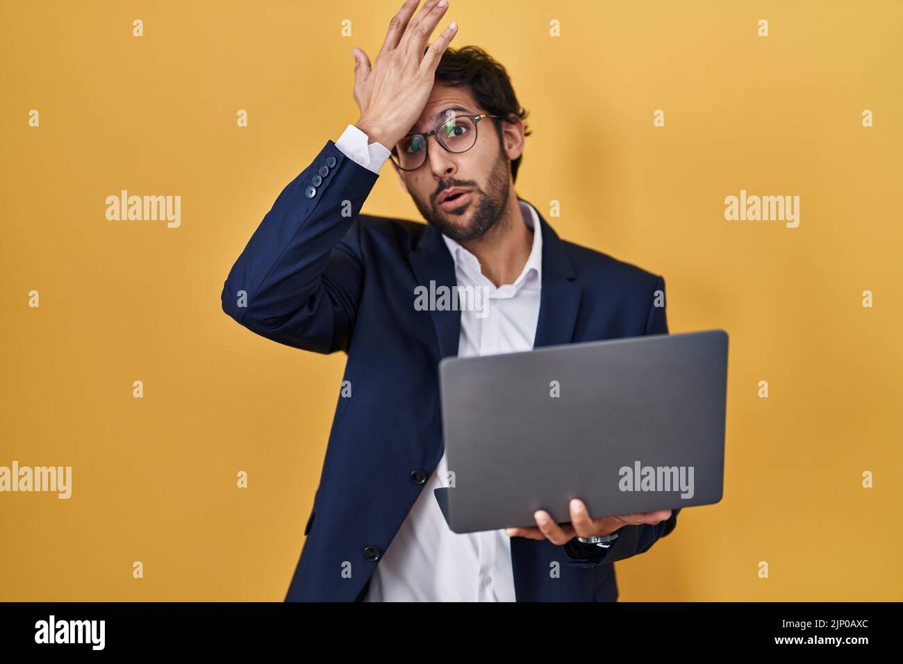Man With Left Hand Computer Handsome latin man working using computer laptop surprised with hand on ...