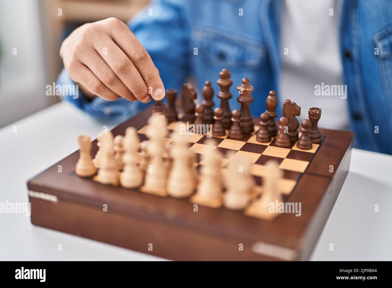 Young arab man playing chess sitting on table at home Stock Photo