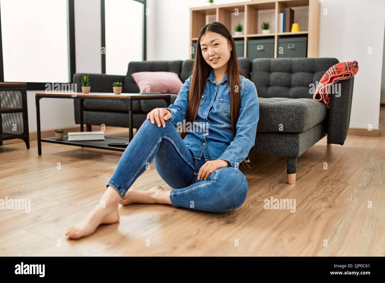 Young chinese girl smiling happy sitting on the floor at home Stock ...