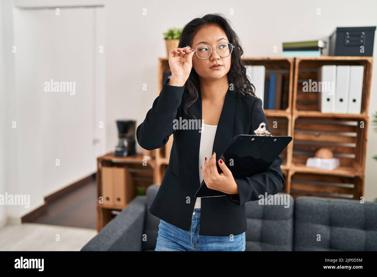 Young chinese woman psychologist holding clipboard standing at clinic Stock Photo Alamy