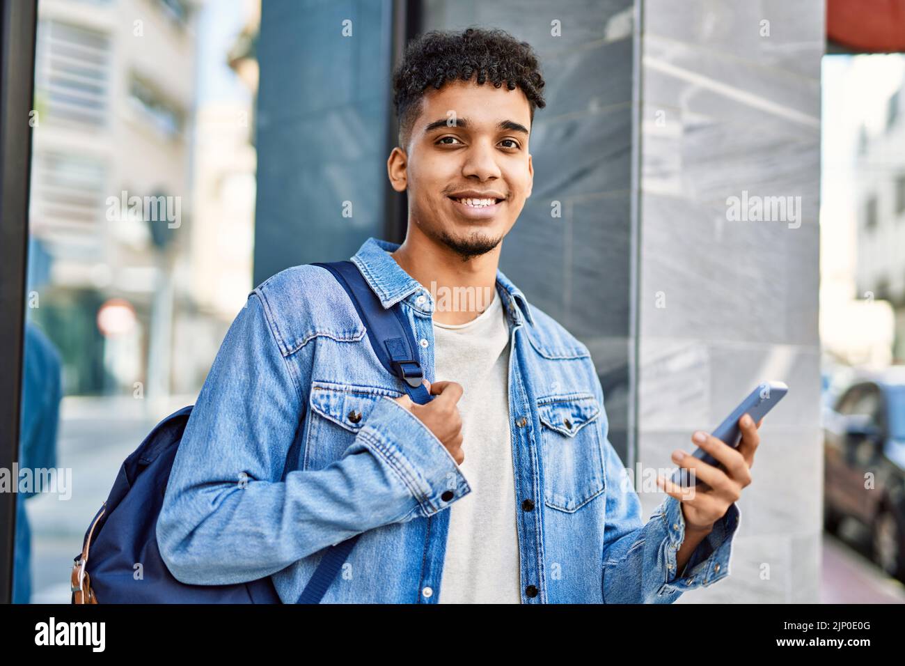 Hispanic young man using smartphone at the university Stock Photo - Alamy