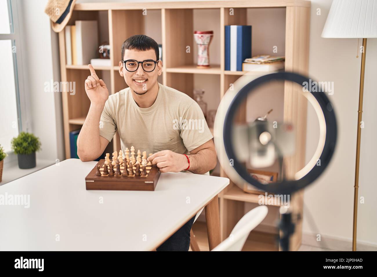 Young arab man doing chess tutorial smiling happy pointing with hand and finger to the side Stock Photo