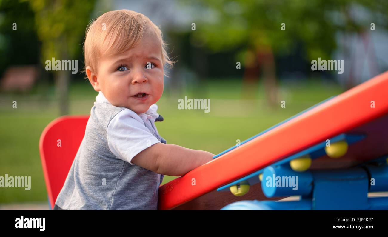 A little boy is swinging on a swing on a beautiful summer day Stock