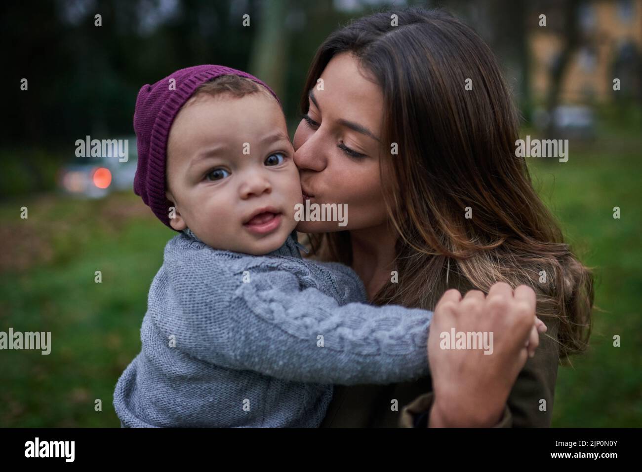 Mommy just cant get enough of my cute cheeks. a mother bonding with her little son outdoors. Stock Photo