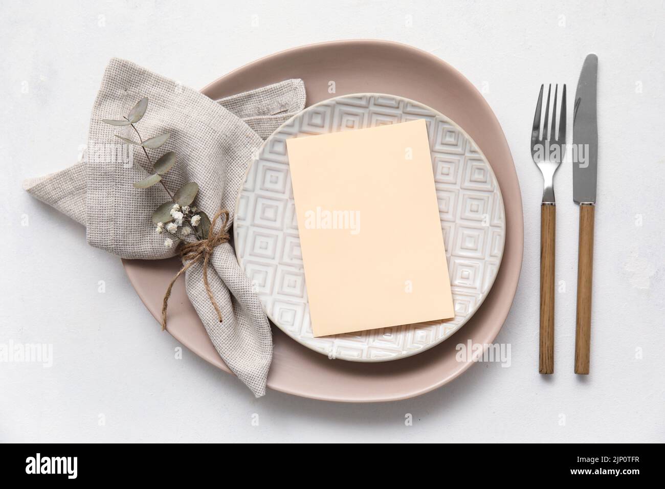 Simple table setting with floral decor on white background Stock Photo