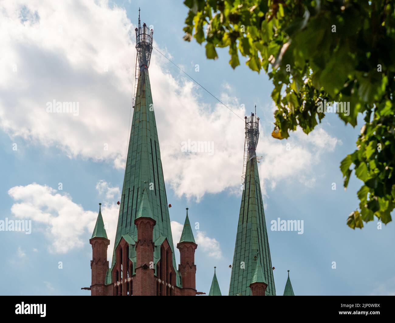 Towers of the St. Bonifatius church in Berlin Kreuzberg. Copper rooftops in green color. The building is built of red bricks in neo-gothic style. Stock Photo