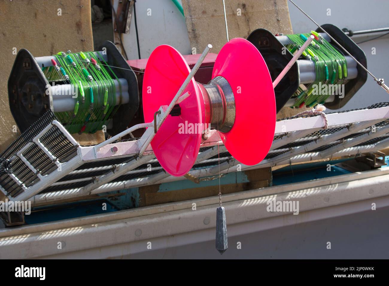 Brightly coloured squid jigging machine reel and lines Stock Photo