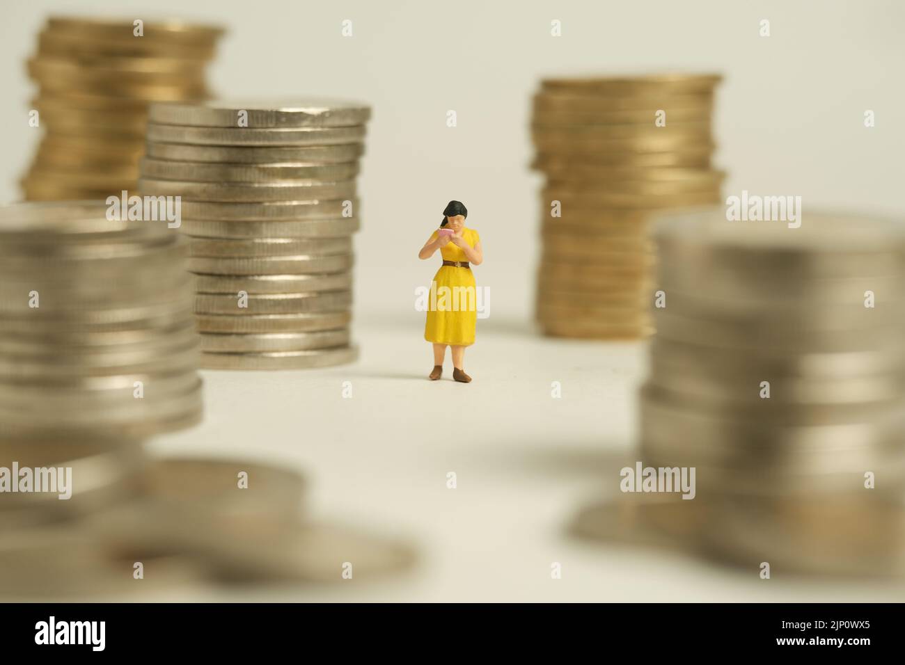 Miniature people toy figure photography. A men student standing the middle of money coin stack, isolated on white background. Image photo Stock Photo