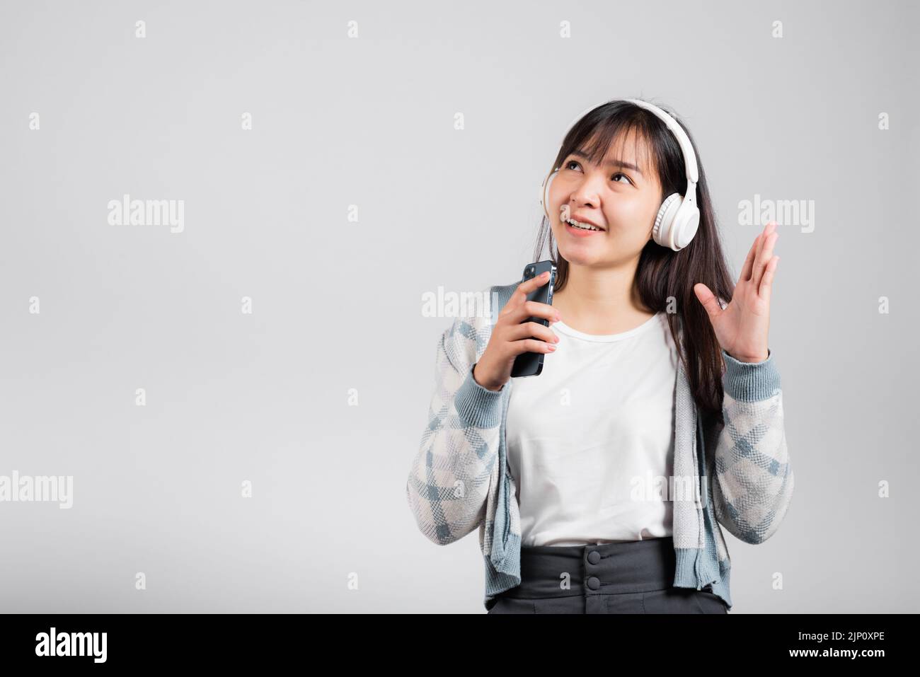 Woman excited smiling listening to music radio in bluetooth headphones ...