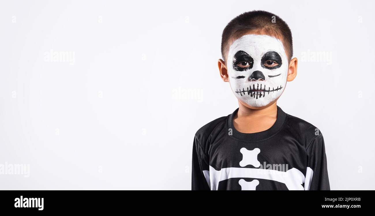 Halloween Kid. Child man horror face painting make up for ghost scary, Portrait of Asian little kid boy wearing skeleton costume studio shot isolated Stock Photo
