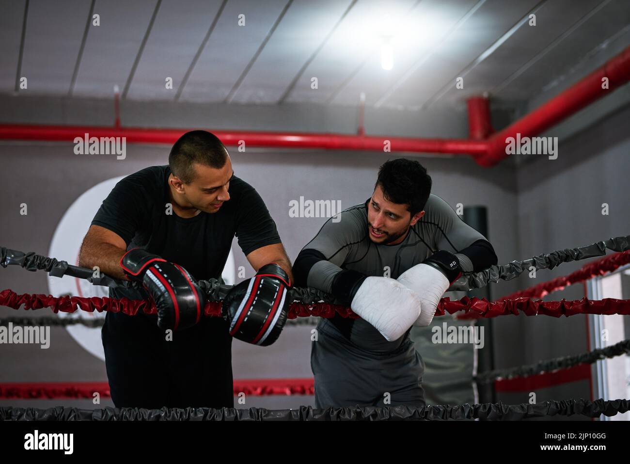 That was a good session. two young male athletes standing in a boxing ring after a sparring session. Stock Photo