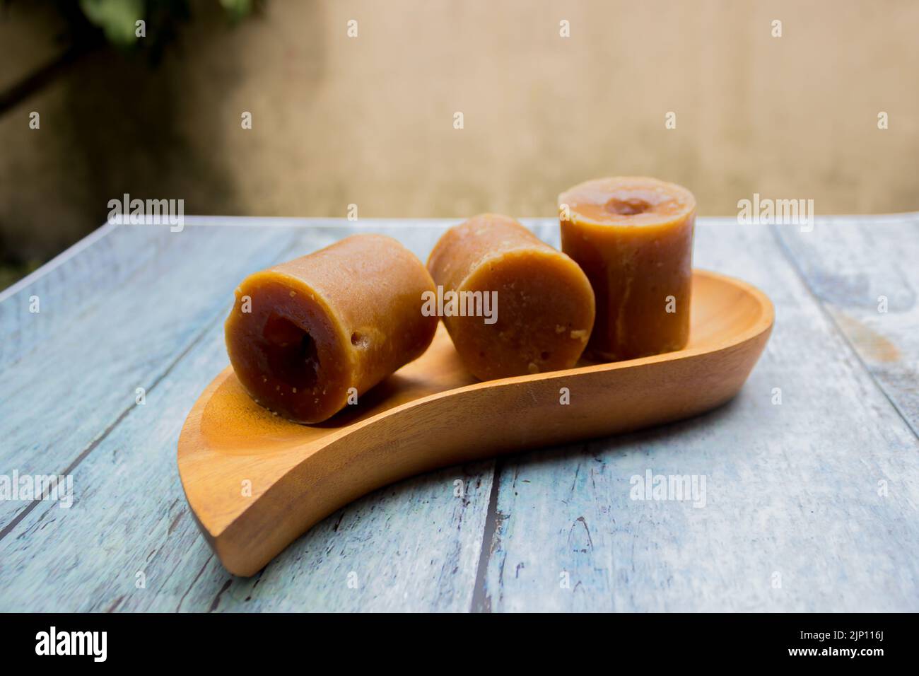 Indonesian brown sugar, palm sugar or gula merah in cubes with wooden tray Stock Photo