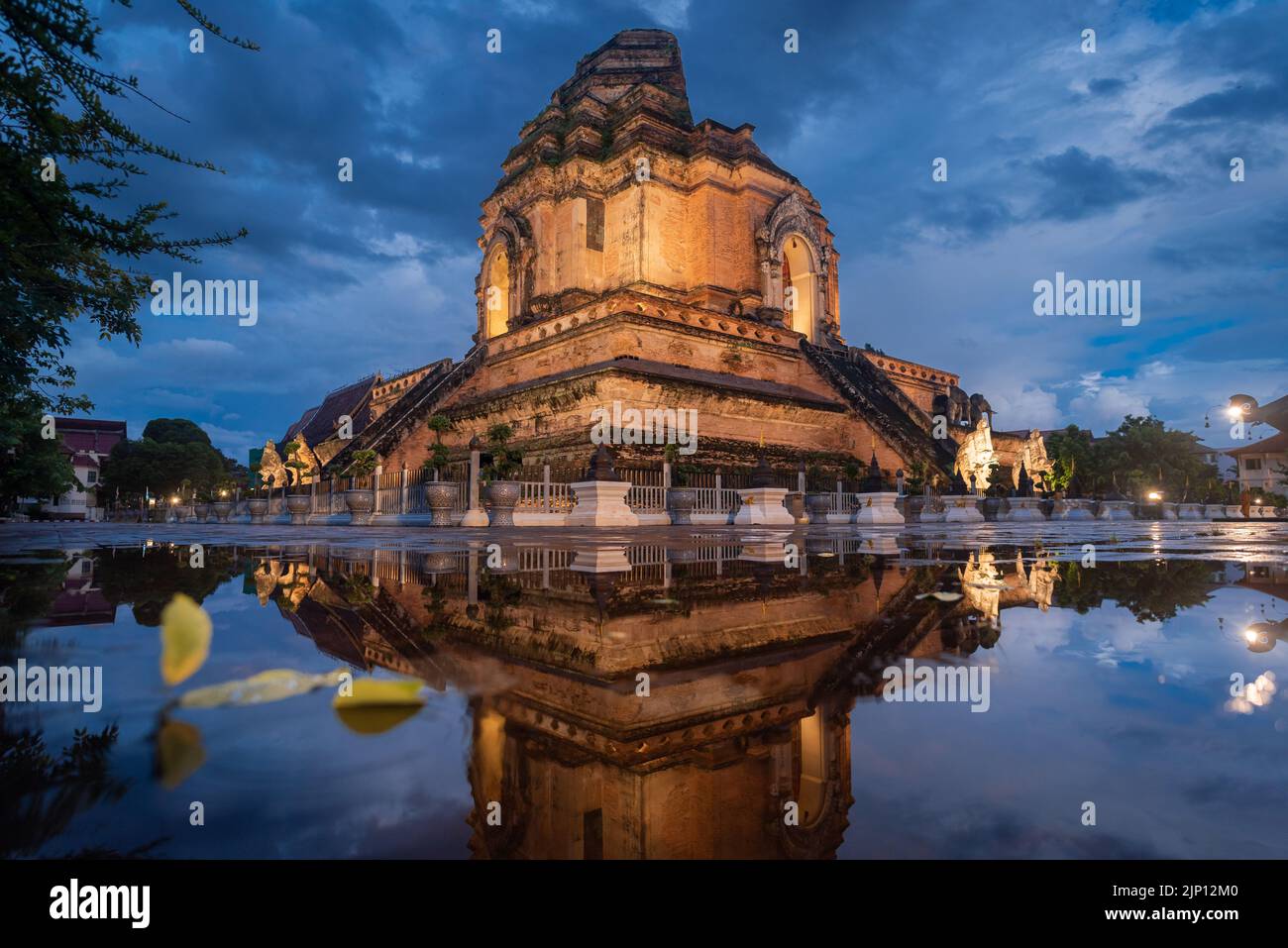 Ancient collapse pagoda reflection in rain water. Chedi Luang temple. Chiang Mai, Thailand. Stock Photo
