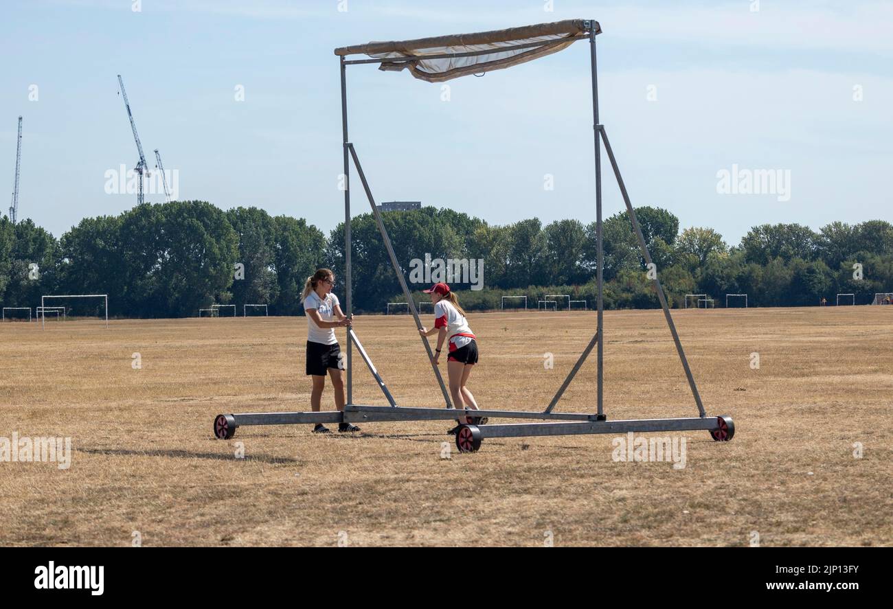 pic shows: Women’s circket match preparations as two wheel sight screen  over Hackney Marshes today which ironically was bone dry and brown  Picture b Stock Photo