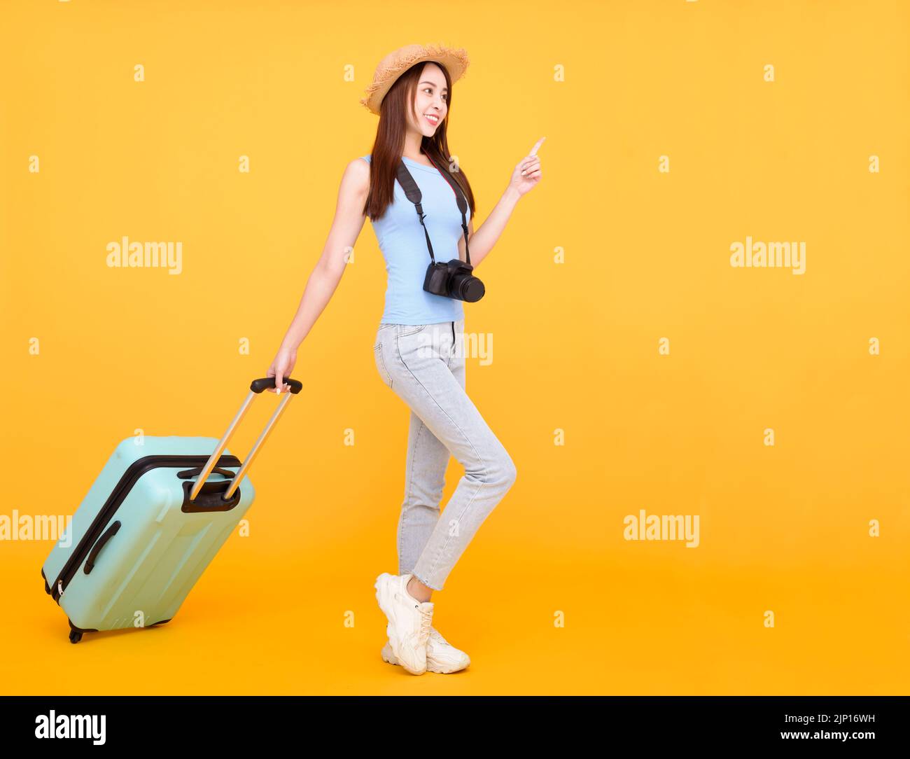 Happy young woman with  luggage and camera isolated on yellow background ,summer,travel concept. Stock Photo