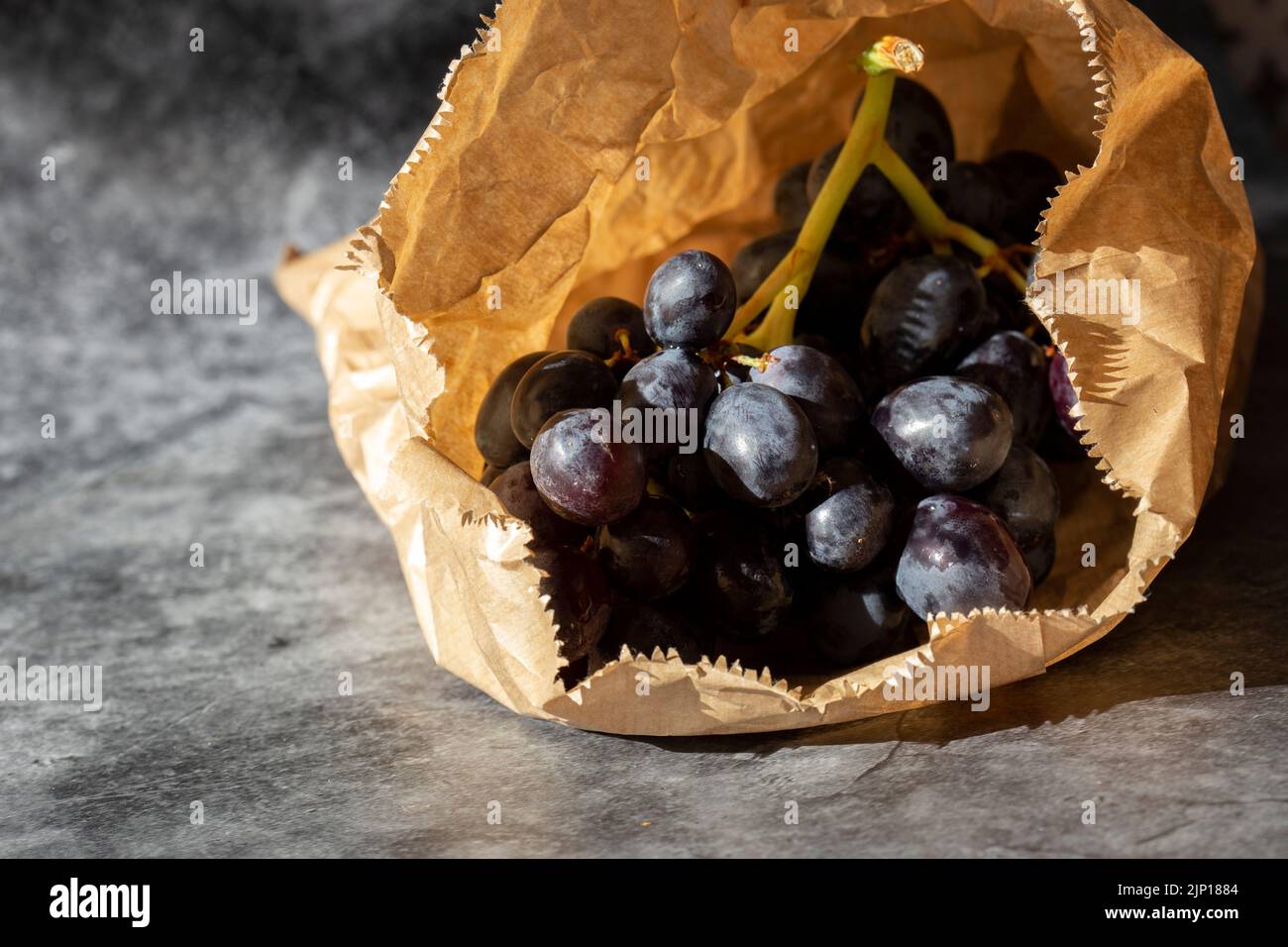Black grapes in a brown paper bag. Eco friendly recycle packaging to