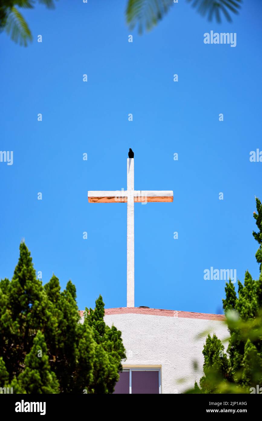 Black crow sitting on the cross on the House of Prayer at Airakuen Leper Colony; Nago, Okinawa Prefecture, Japan Stock Photo