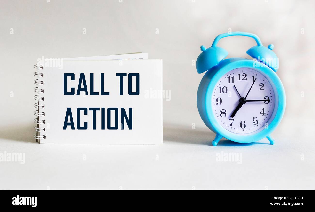 Text Call to Action on notepad and white background with clock. Conceptual image Stock Photo