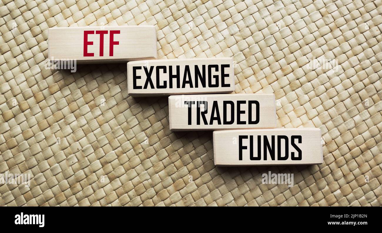 Mutual funds vs. ETF symbol. Cubes with the words ETF Exchange Traded Fund and Mutual Funds. Beautiful beige background. Stock Photo