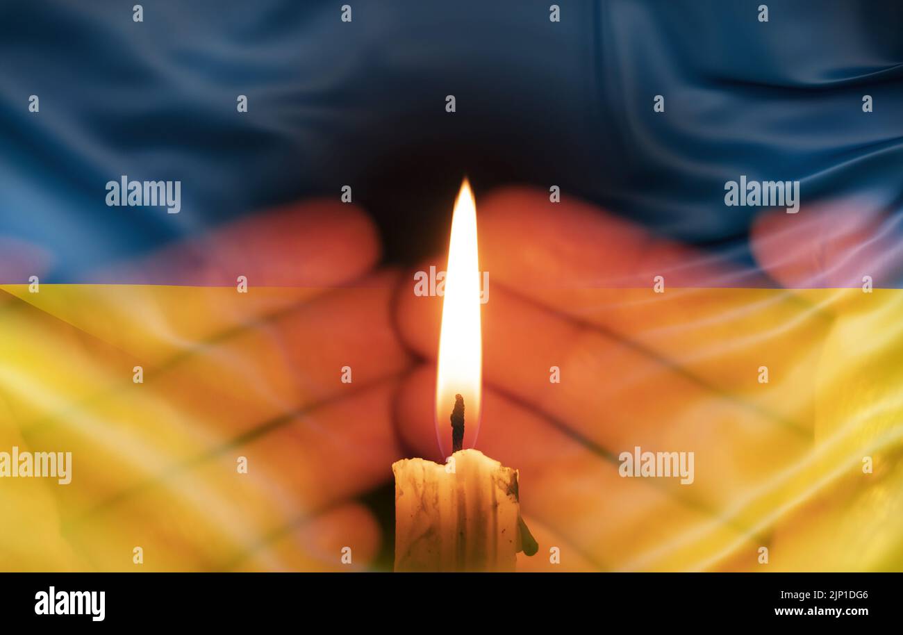 a burning candle against the background of the national flag of Ukraine, yellow-blue, peace in Ukraine, no war Stock Photo