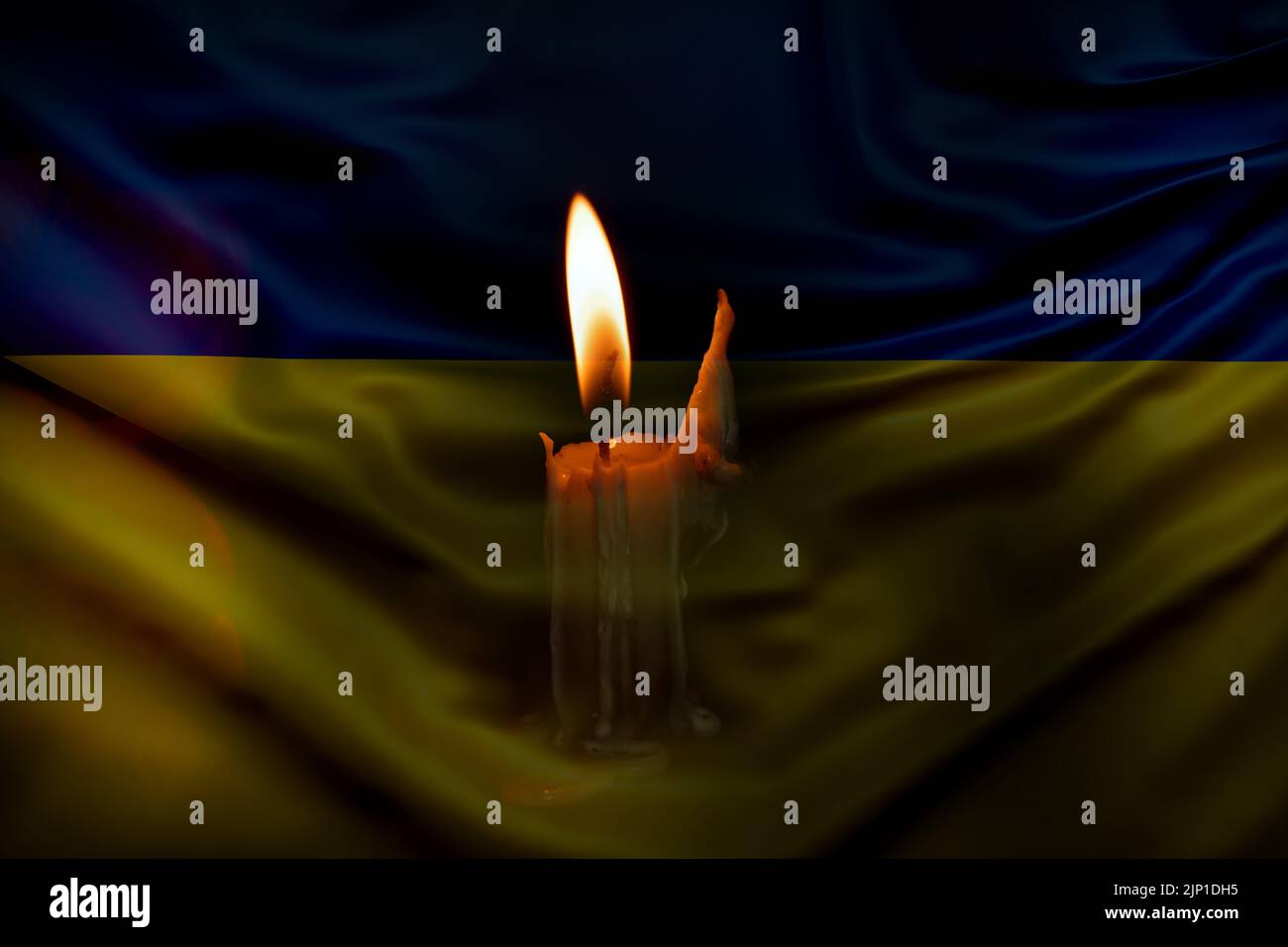 a burning candle against the background of the national flag of Ukraine, yellow-blue, peace in Ukraine, no war Stock Photo
