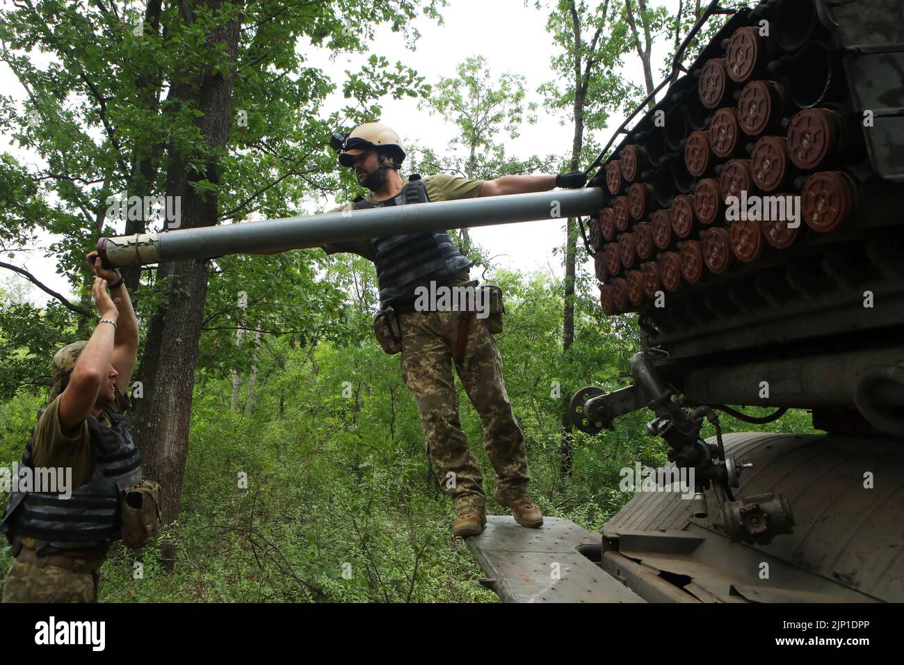UKRAINE - AUGUST 12, 2022 - Servicemen of Ukraine's Armed Forces load missiles into a BM-21 Grad multiple rocket launcher as they get ready to perform Stock Photo