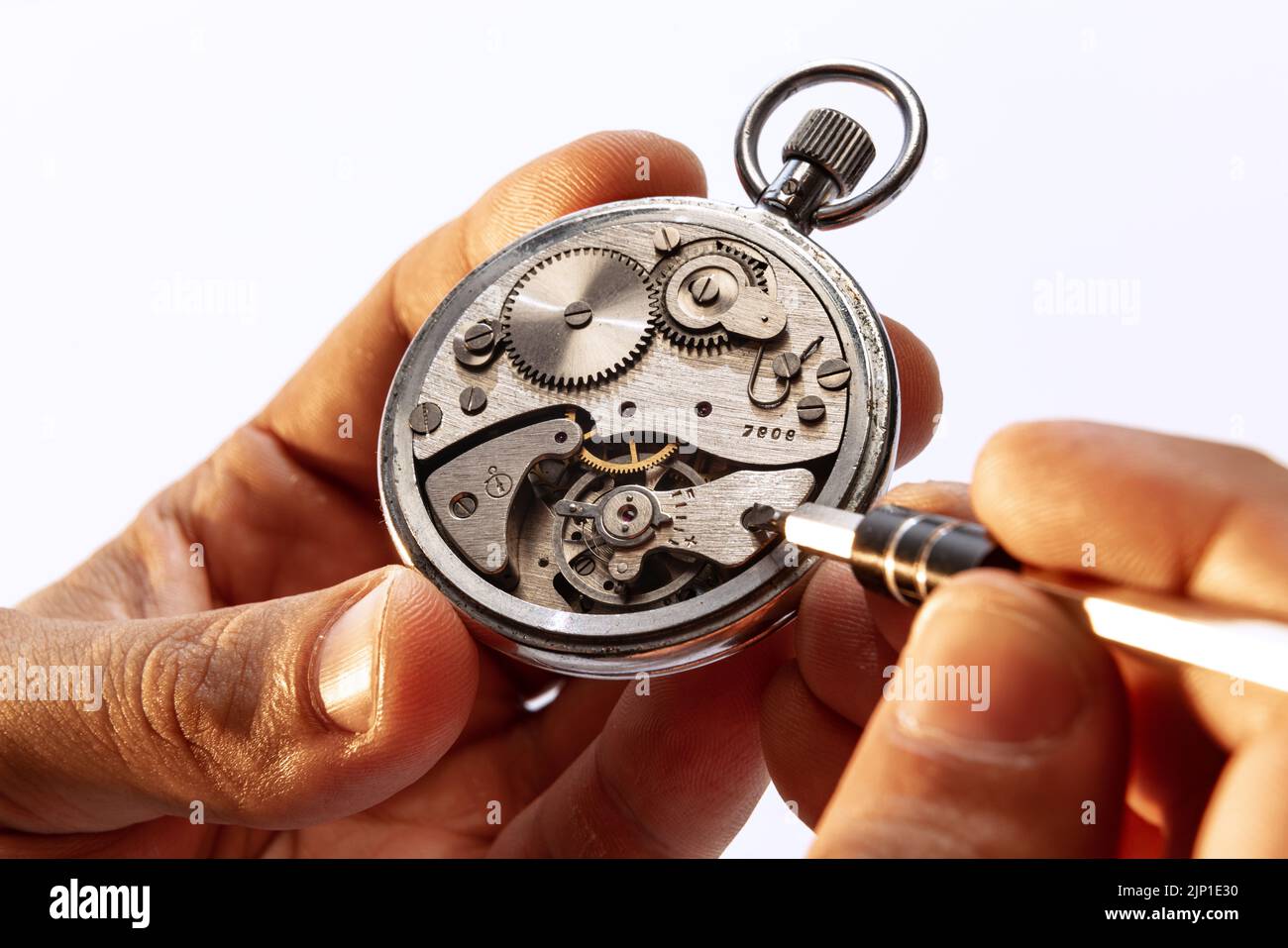 Closeup watchmaker's hands repairing mechanical watches isolated over