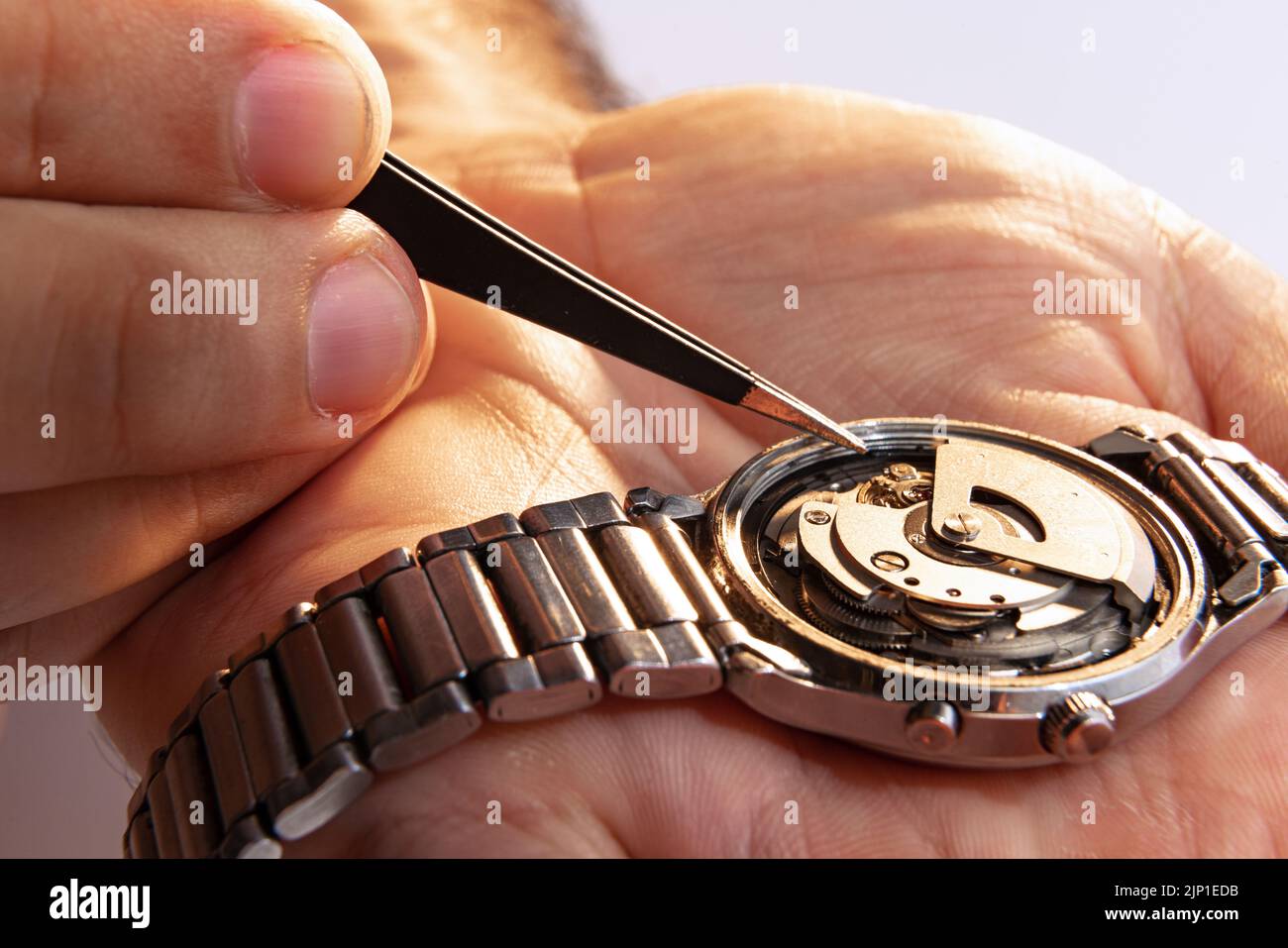 Watchmaker's job. Closeup male hands holding mechanical watches