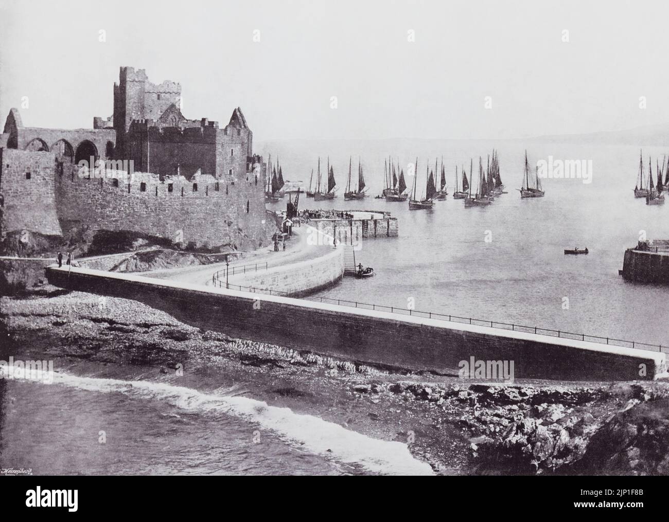 Peel, Isle of Man. The old castle and harbour, seen here in the 19th century. From Around The Coast,  An Album of Pictures from Photographs of the Chief Seaside Places of Interest in Great Britain and Ireland published London, 1895, by George Newnes Limited. Stock Photo