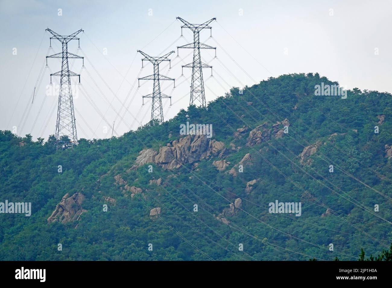 YANTAI, CHINA - AUGUST 14, 2022 - A high-voltage transmission line is seen in a mountainous area in Yantai, Shandong Province, China, Aug 14, 2022. St Stock Photo