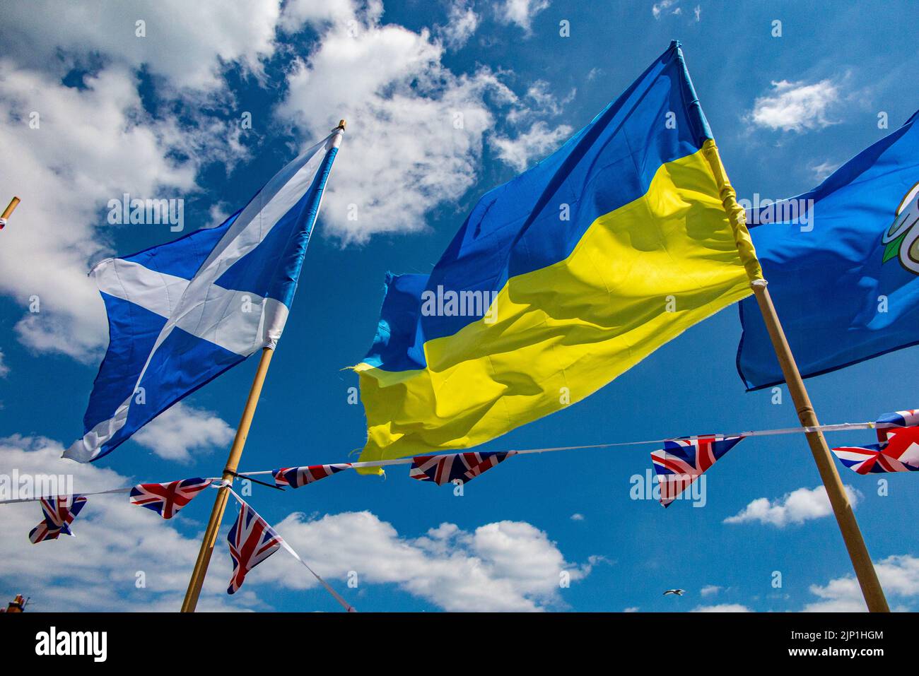 The Scottish and Ukranian flags flutter on a summers day in England Stock Photo