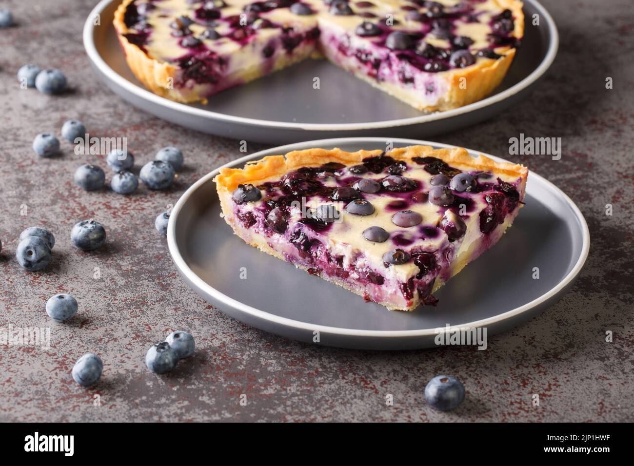 Mustikkapiirakka a Finnish Blueberry Pie Tart sliced close-up in a plate on a table. Horizontal Stock Photo