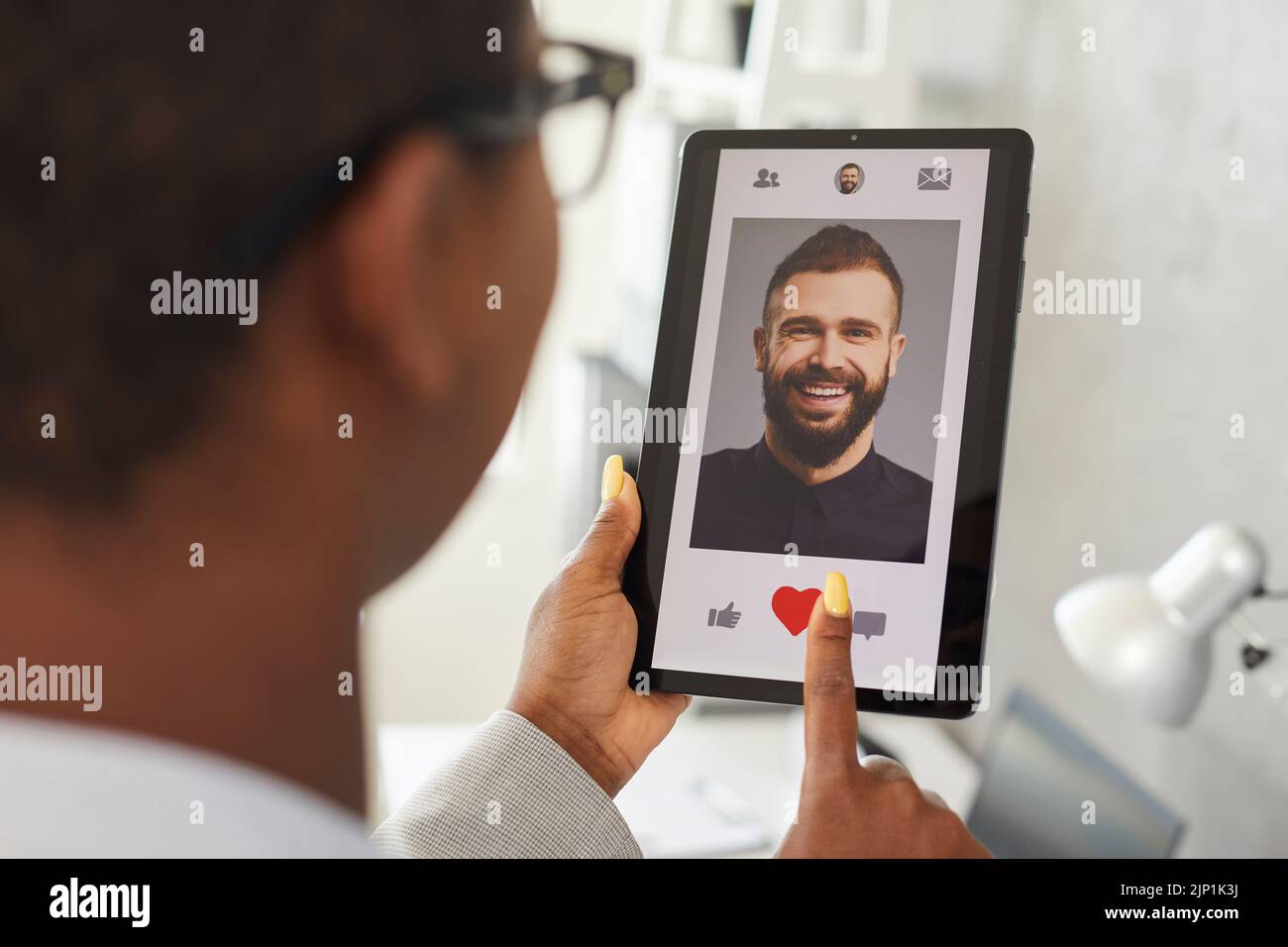 Woman gives like to profile picture of young man on online dating app or website Stock Photo
