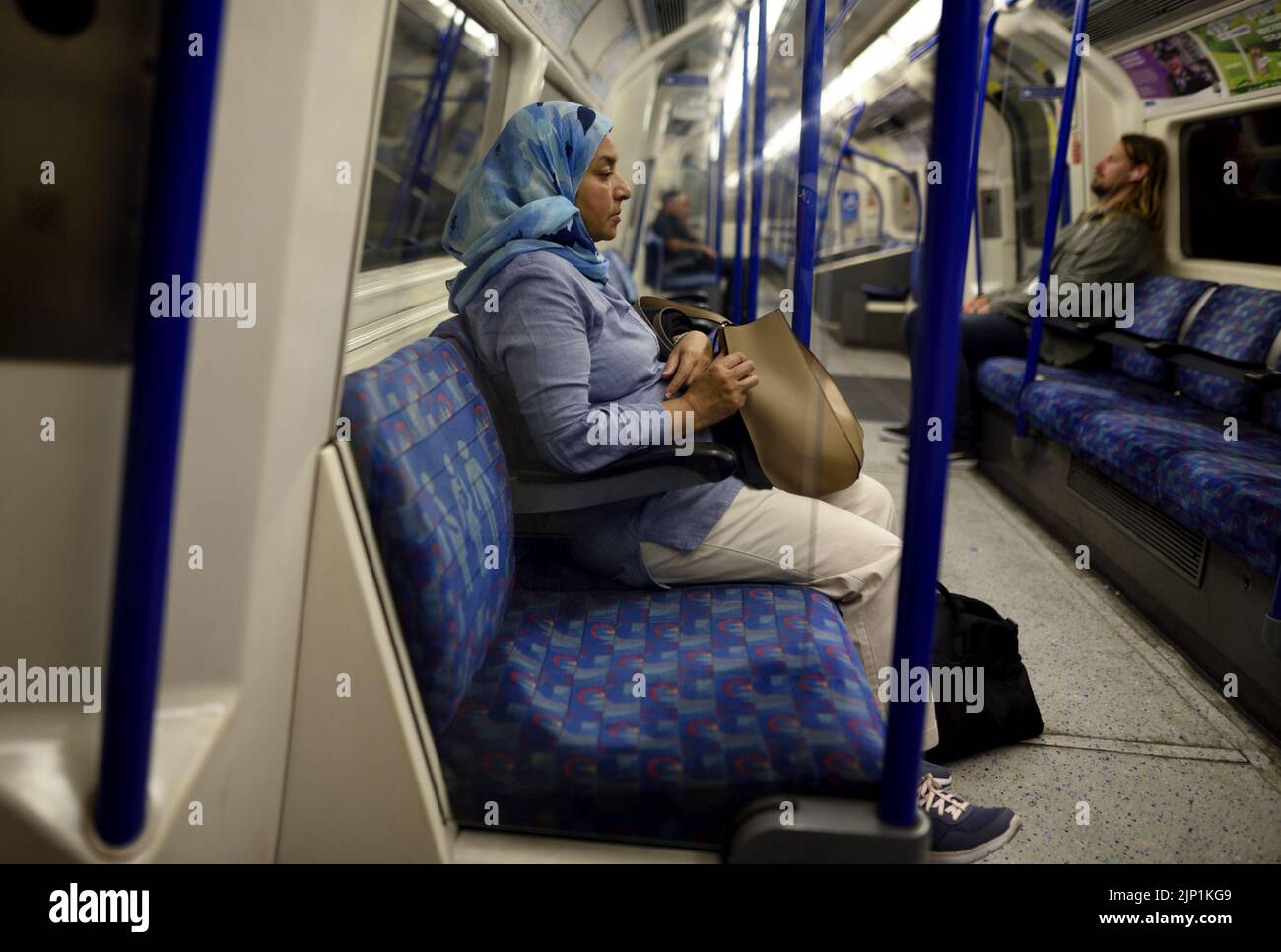 London, England, UK. London Underground - Muslim woman wearing a headscarf traveling alone Stock Photo