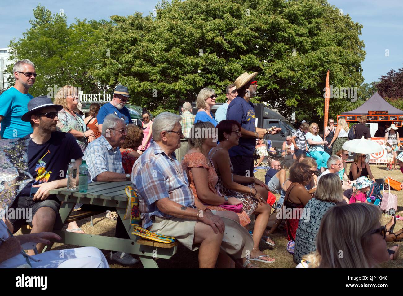 People watching music performers at Art in the Park, Leamington Spa, Warwickshire, UK. August 2022 Stock Photo