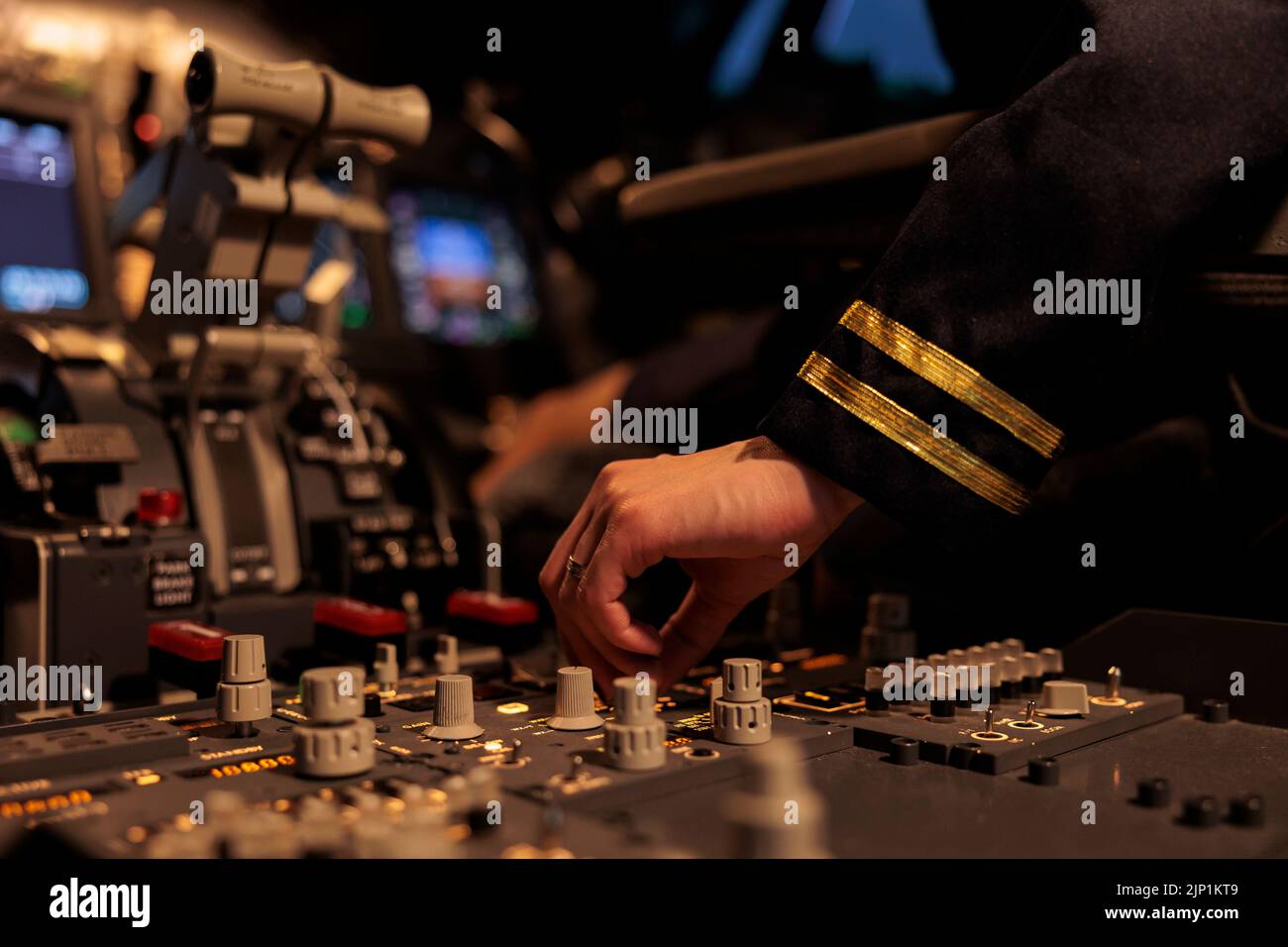 Woman copilot using control panel command on dashboard navigation to fly ariplane in cockpit. Female airliner flying plane in cabin with power engine and switch lever. Close up. Stock Photo