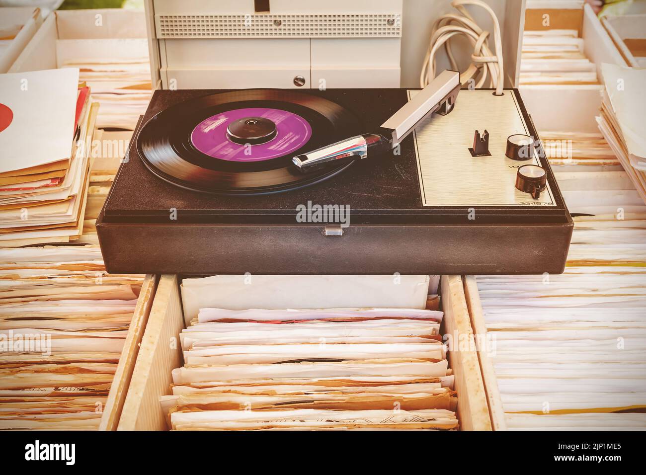 Retro styled image of an old record player on top of used vinyl lp records Stock Photo
